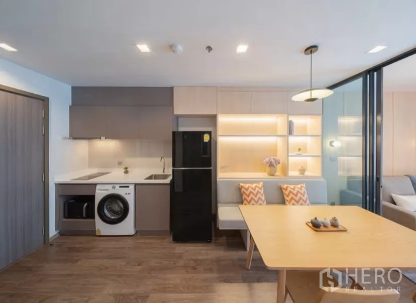 คอนโด ให้เช่าในChatuchak, Bangkok - ครัวย่อมพร้อมเตาไฟฟ้า อ่างล้างจาน เครื่องซักผ้า และตู้เย็นสีดำข้างชั้นวางไฟสวย