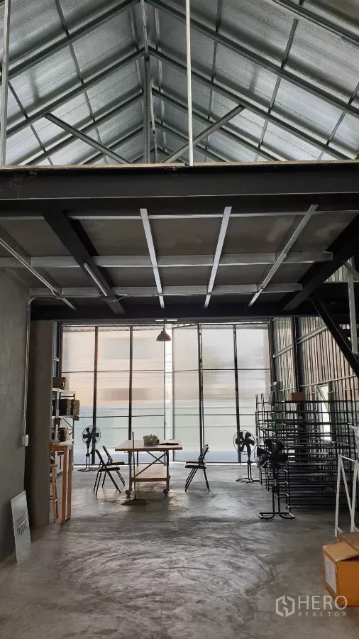 货栈 出租在Chatuchak, Bangkok - 高挑仓库工作区，正面大面积玻璃立面，置物架与桌子。