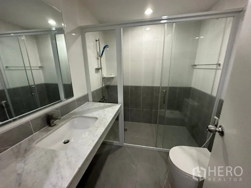 คอนโด ให้เช่าในWatthana, Bangkok - ห้องน้ำร่วมสมัย เคาน์เตอร์หินอ่อนยาว โถสุขภัณฑ์ และตู้กระจกอาบน้ำ