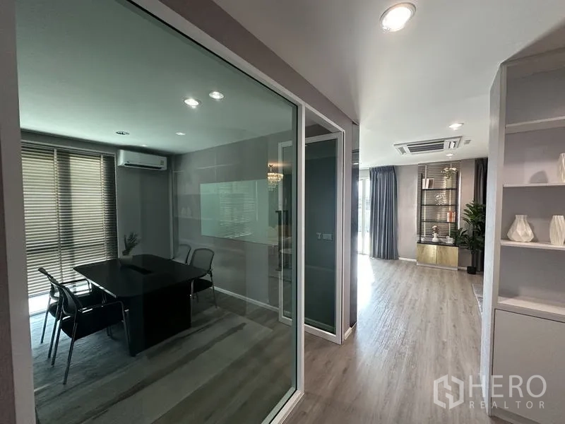 Factory for sale in Lam Luk Ka, Pathum Thani - Glass-walled meeting room next to a corridor with light wood flooring.