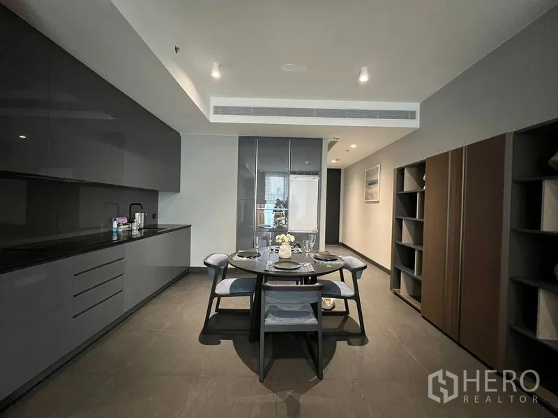 Condominium for rent in Bang Rak, Bangkok - Modern grey kitchen with dining table set for four.
