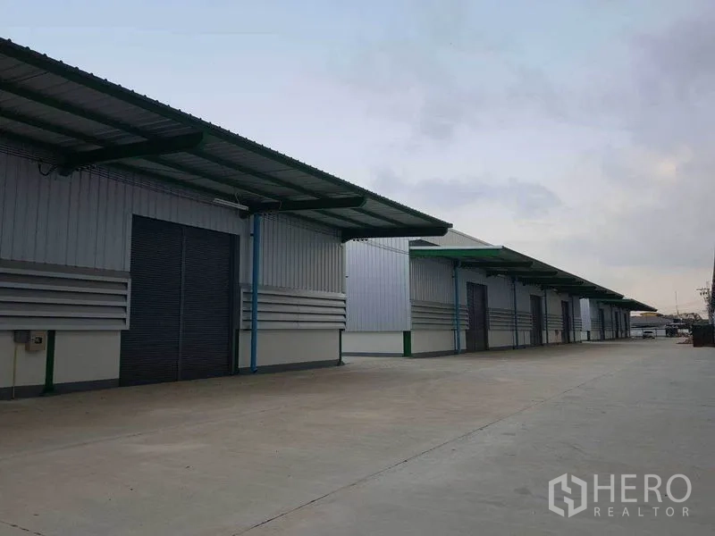 货栈 出租在Prawet, Bangkok - 多间仓库单元配雨棚与卷闸门，前有大型调头区。