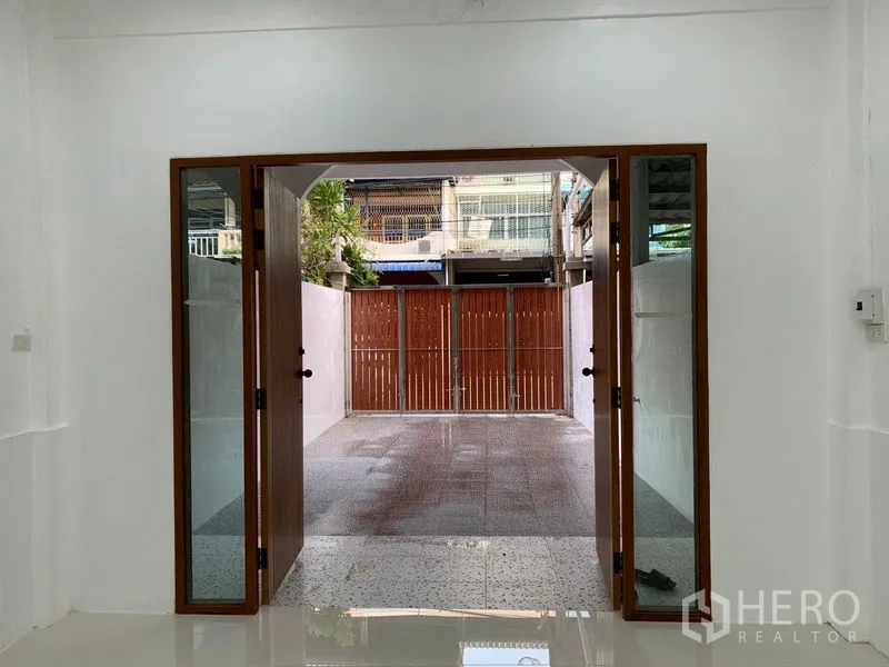 ทาวน์เฮาส์ ขายในYan Nawa, Bangkok - ประตูกระจกเปิดสู่ลานหน้าบ้านปูกระเบื้องและรั้วไม้