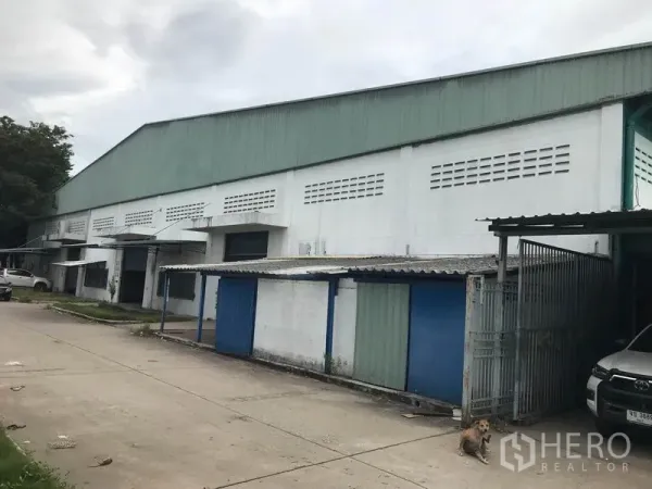 โรงงาน ให้เช่าในMueang Chon Buri, Chon Buri - ด้านหน้าโรงงานขนาดใหญ่ มีช่องโหลดสินค้าและประตูม้วน พร้อมทางวิ่งคอนกรีตกว้าง