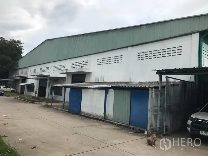 โรงงาน ให้เช่าในMueang Chon Buri, Chon Buri - ด้านหน้าโรงงานขนาดใหญ่ มีช่องโหลดสินค้าและประตูม้วน พร้อมทางวิ่งคอนกรีตกว้าง