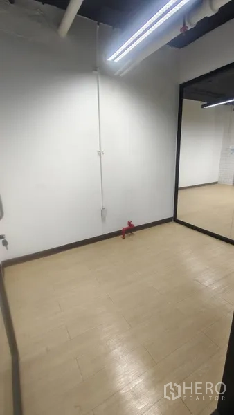 办公空间 出租在Pathum Wan, Bangkok - 紧凑房间，浅木纹地板与大镜面墙，适合储物或电话间。