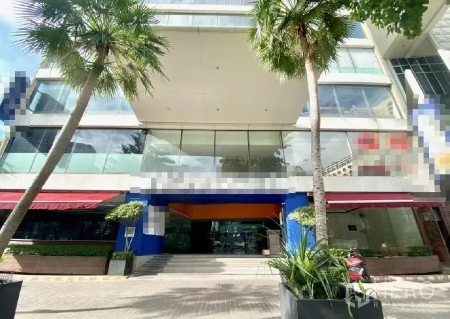 零售空间 出租在Pathum Wan, Bangkok - 现代商业楼正门，成排棕榈树与宽阔人行道。