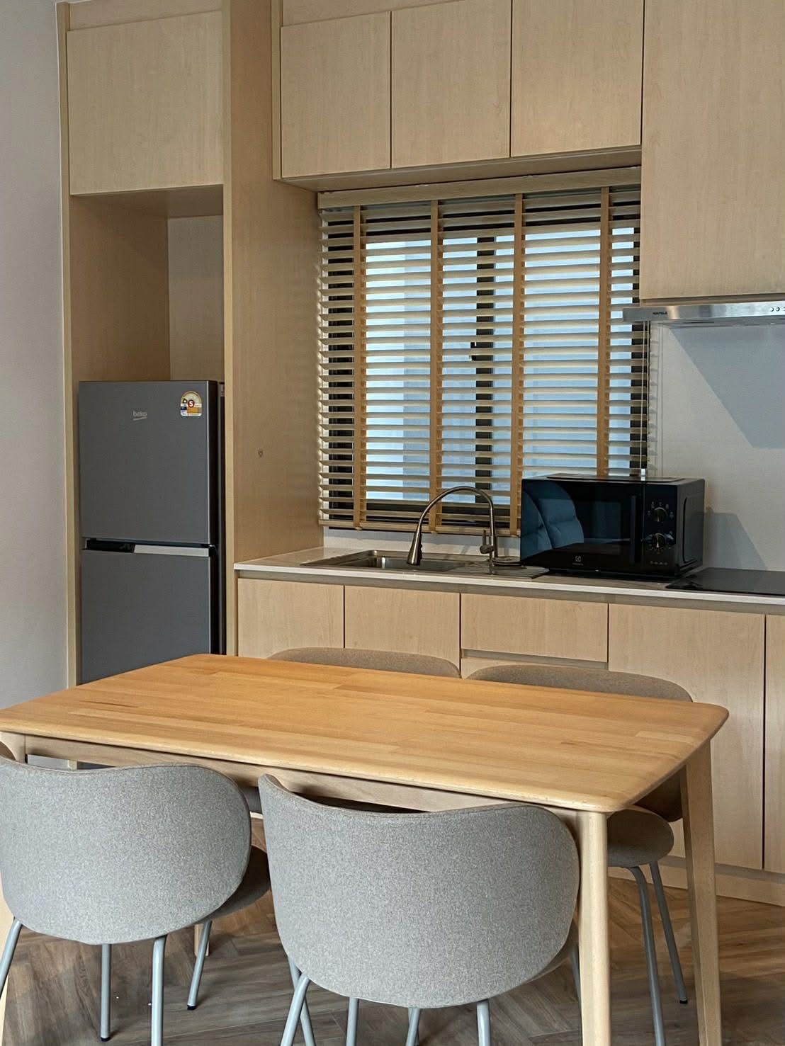 ทาวน์เฮาส์ ให้เช่าในBang Phli, Samut Prakan - ครัวโทนไม้สว่าง โต๊ะรับประทานอาหาร ตู้เย็น ไมโครเวฟ และอ่างล้างจาน.