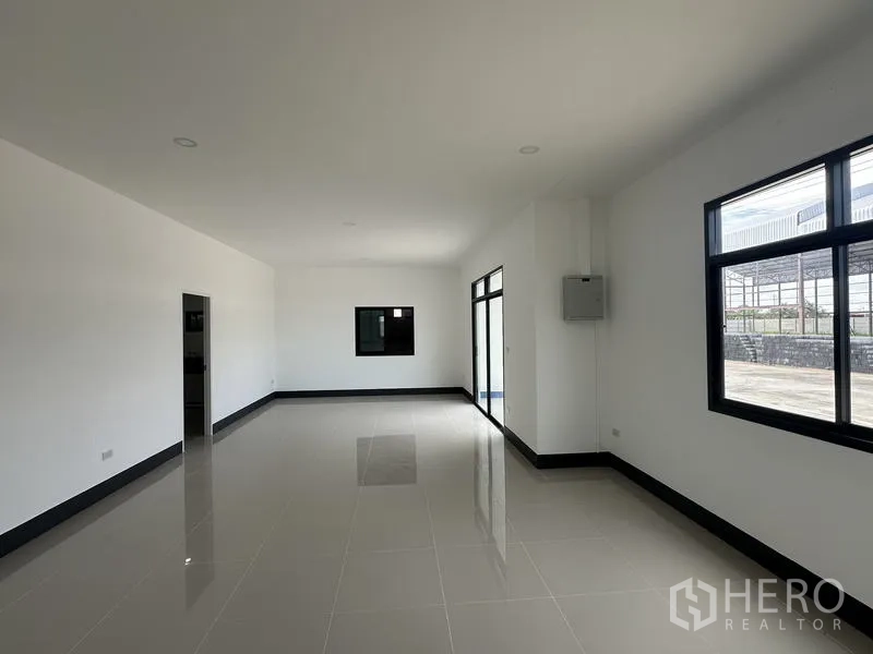 工厂 出租或出售在Sai Noi, Nonthaburi - 大开间办公室，落地窗俯瞰外部场地。