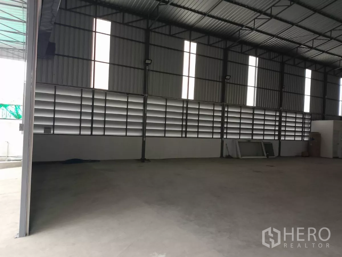 Warehouse for rent in Huai Khwang, Bangkok - Interior wall of the warehouse showing horizontal louver vents and an open entrance.