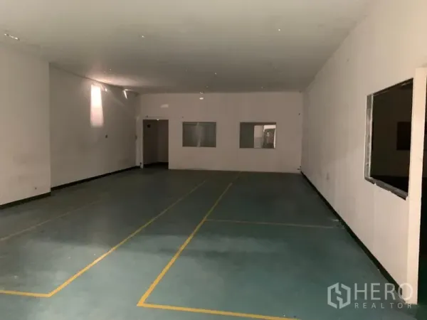 工厂 出租在Pathum Thani - 宽敞作业室，地面划线，内窗与出入口清晰可见。