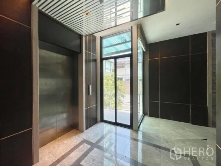 Detached House for rent or sale in Khlong Toei, Bangkok - Entrance foyer with lift and full-height glass door overlooking the street.