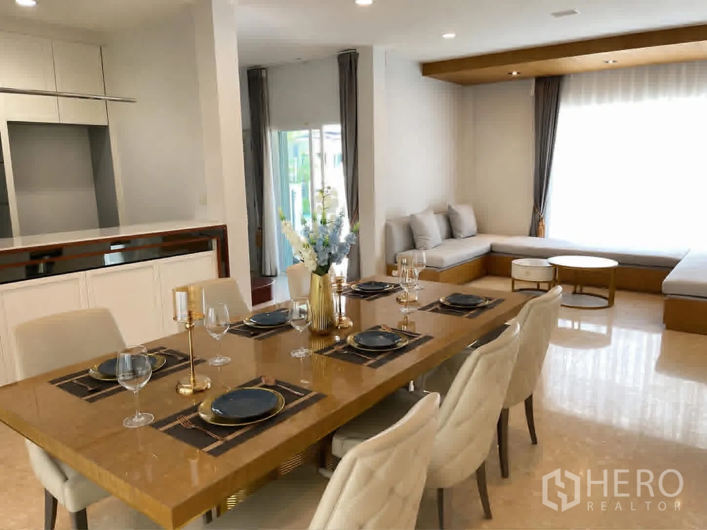 Detached House for rent or sale in Saphan Sung, Bangkok - Dining area set for six beside lounge seating and large windows.