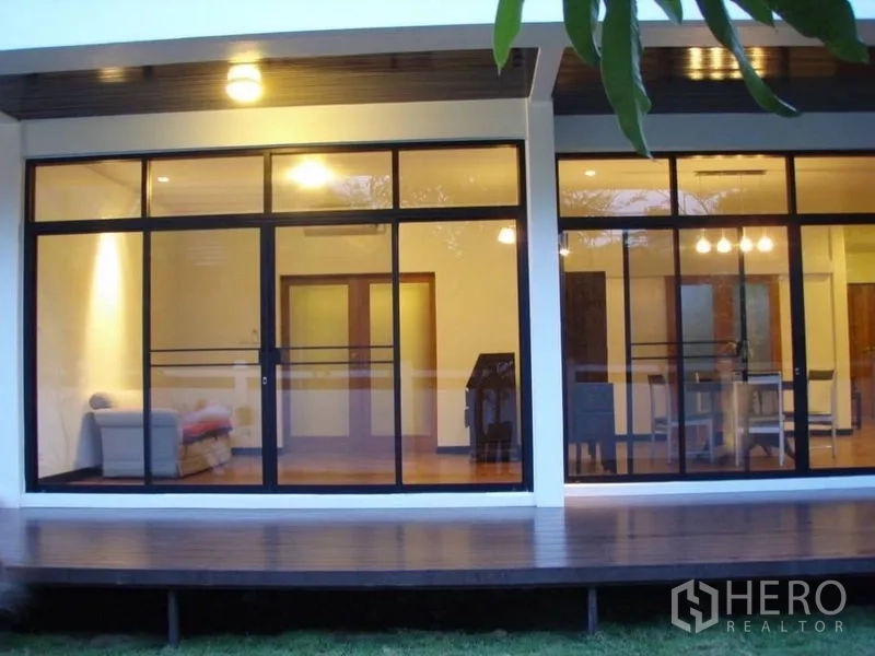 บ้าน ให้เช่าในHuai Khwang, Bangkok - ด้านหน้าบ้านกระจกทั้งแผง ภายในสว่างไสว พร้อมเฉลียงไม้ยกพื้น
