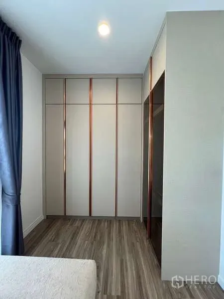 Detached House for rent in Bang Kapi, Bangkok - Floor-to-ceiling wardrobe and wood flooring in a secondary bedroom.