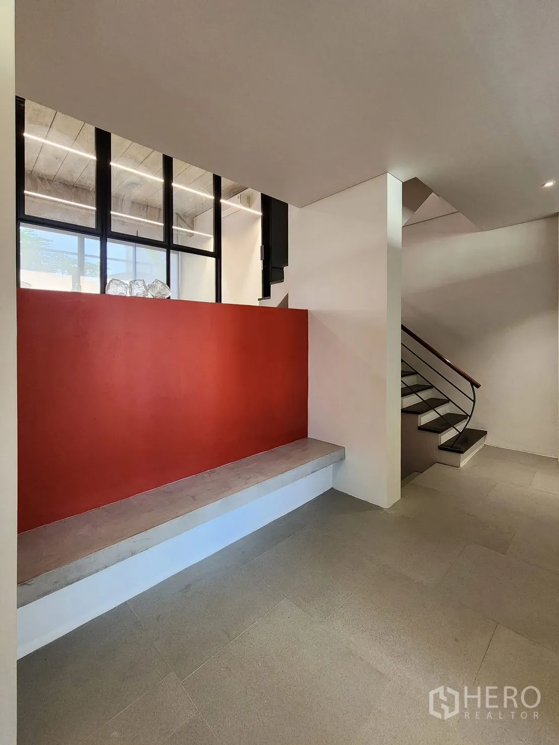 家庭办公室 for rent in Chatuchak, Bangkok - 入口大堂，内置长凳、红色特色墙与通往楼上的楼梯。