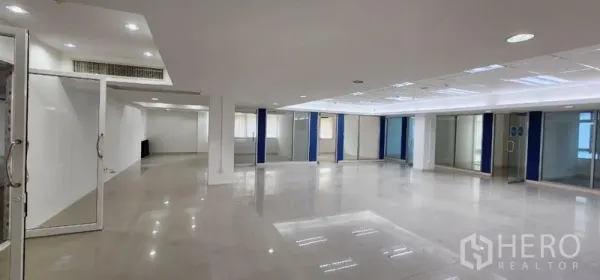 Office Space for rent in Chatuchak, Bangkok - Bright office hall with wide open space, glass doors, and blue-accent pillars for private meeting rooms.