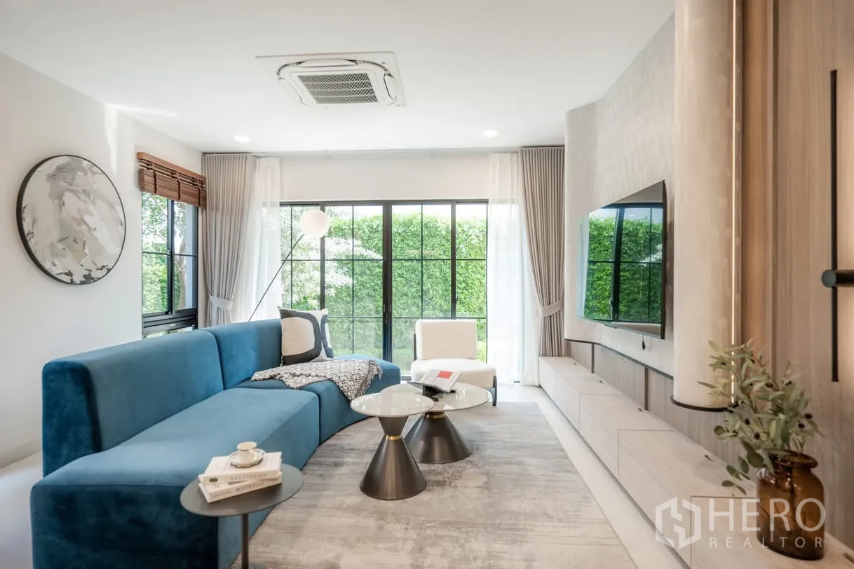 บ้านเดี่ยว for rent in Saphan Sung, Bangkok - ห้องนั่งเล่น โซฟาสีน้ำเงิน หน้าต่างบานใหญ่ และประตูกระจกมองเห็นสวน