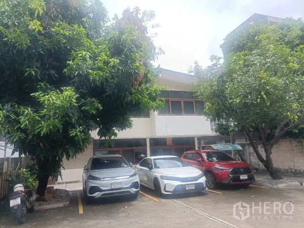 Detached House for rent in Bang Rak, Bangkok - Front courtyard parking area with three cars under shade trees facing the house.