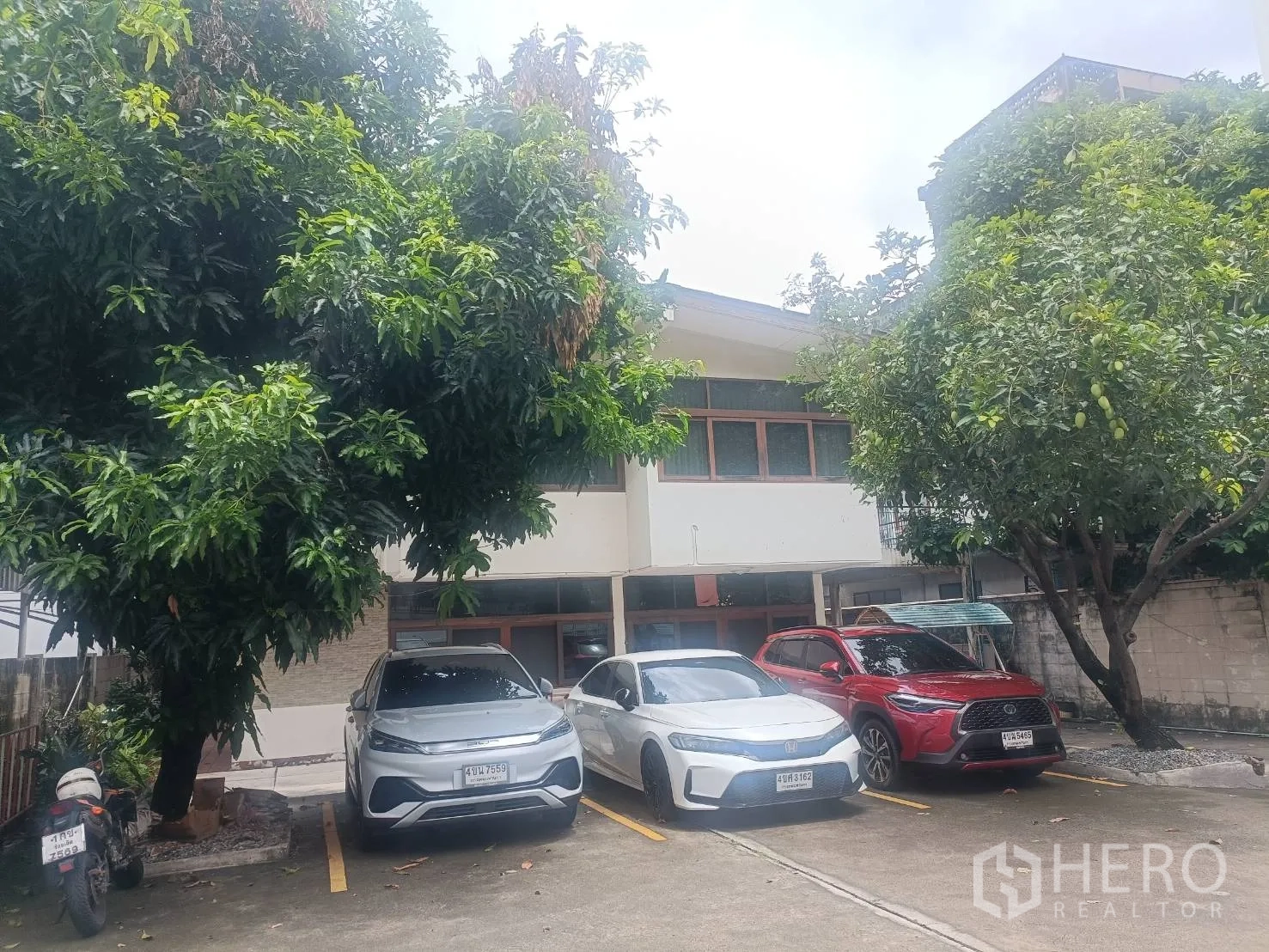Detached House for rent in Bang Rak, Bangkok - Front courtyard parking area with three cars under shade trees facing the house.