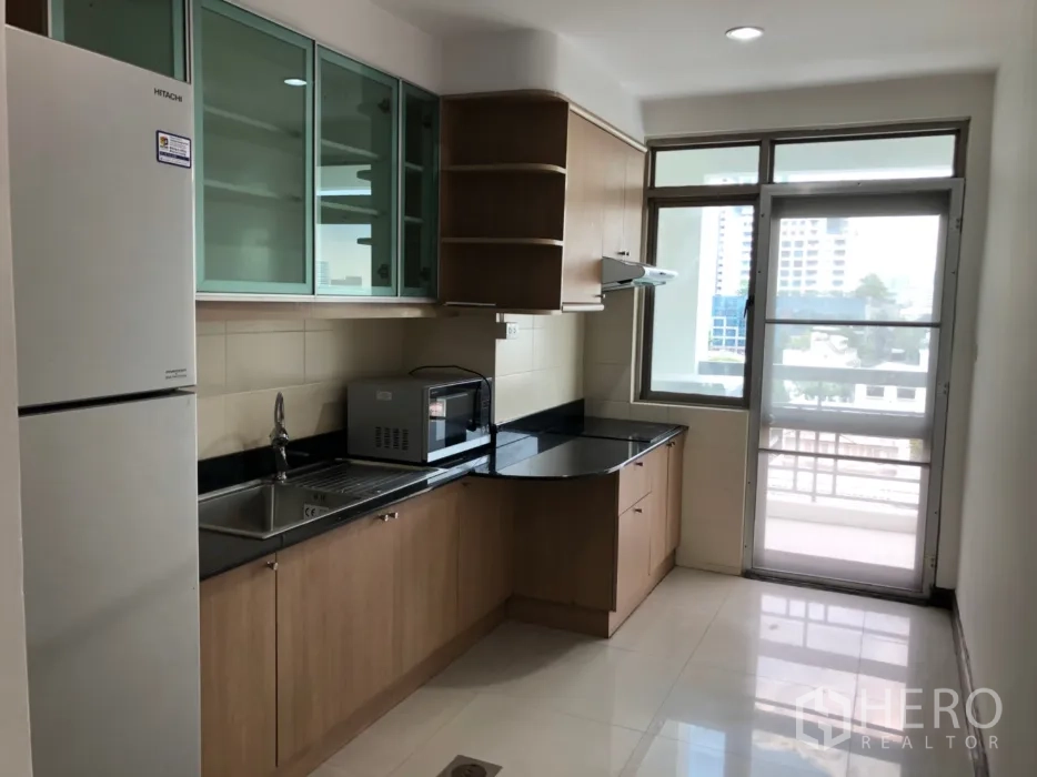 คอนโด ให้เช่าในWatthana, Bangkok - ครัวแยกเคาน์เตอร์ตัวแอล ตู้กระจกฝ้า ตู้เย็น ไมโครเวฟ และทางออกสู่ระเบียง