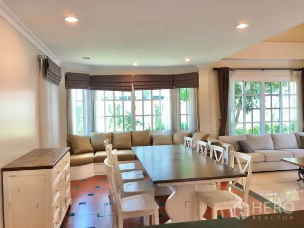 独立式住宅 出租在Mueang Samut Prakan, Samut Prakan - 开放式餐区，长餐桌与飘窗卡座，嵌灯和落地窗