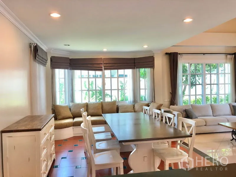 独立式住宅 出租在Mueang Samut Prakan, Samut Prakan - 开放式餐区，长餐桌与飘窗卡座，嵌灯和落地窗
