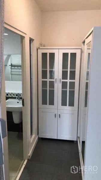 Detached House for rent or sale - Hallway with white glass-door cabinets leading to bathroom.