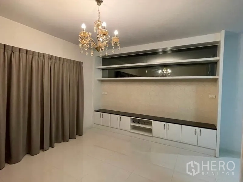 Detached House for sale in Khlong Toei, Bangkok - Living room featuring chandelier lighting and a built-in TV wall cabinet.
