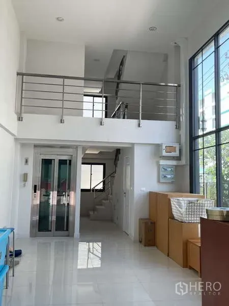 Home Office for rent or sale in Suan Luang, Bangkok - Bright double-height lobby of a 4.5-storey home office with floor-to-ceiling windows, mezzanine, stairs and a private elevator.