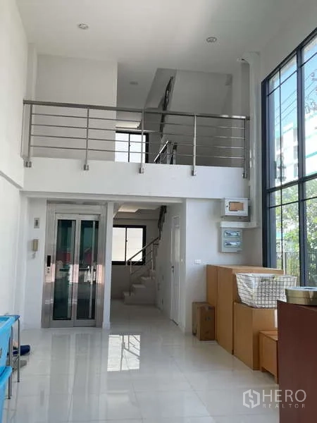 Home Office for rent or sale in Suan Luang, Bangkok - Bright double-height lobby of a 4.5-storey home office with floor-to-ceiling windows, mezzanine, stairs and a private elevator.