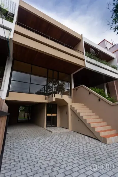 Home Office for rent in Watthana, Bangkok - Modern 3-storey home office exterior with wide 6‑m frontage, glass façade and stairway in Thonglor.