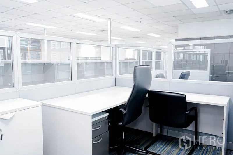 Office Space for rent in Watthana, Bangkok - Two workstations with glass-partitioned cubicles and ergonomic chairs.