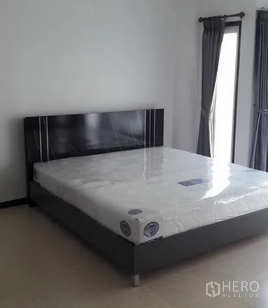 สำนักงานที่บ้าน ให้เช่าในKhlong Toei, Bangkok - ห้องนอนสว่างพร้อมเตียงใหญ่ หัวเตียงสีเข้ม และหน้าต่างสูงพร้อมผ้าม่านสีเทา