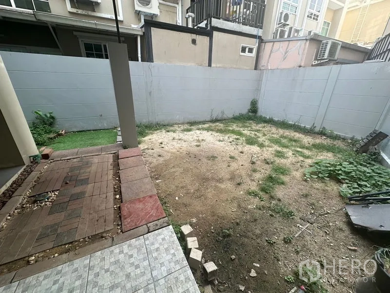 带办公室的家 出租在Bang Na, Bangkok - 围墙式私家庭院，局部铺砖与待美化的土地。