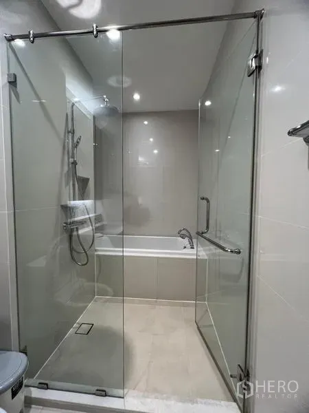 公寓 出租在Khlong Toei, Bangkok - 浴室设玻璃雨淋淋浴间，并配有独立浴缸。