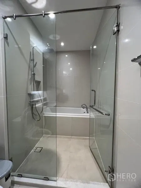 公寓 出租在Khlong Toei, Bangkok - 浴室设玻璃雨淋淋浴间，并配有独立浴缸。