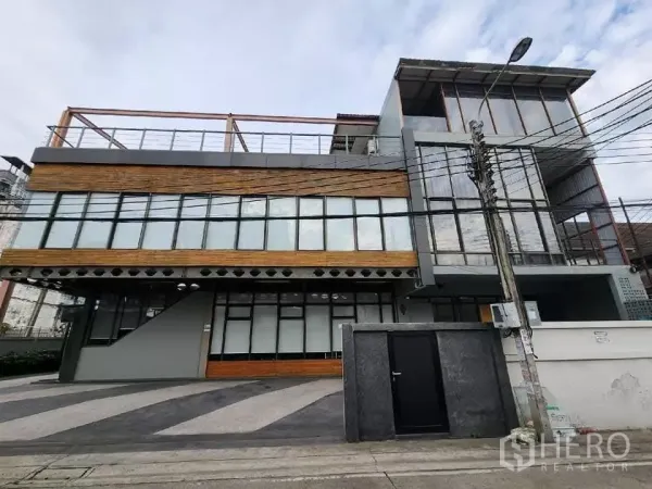 Home Office for rent in Mueang Nonthaburi, Nonthaburi - Modern three-storey home office facade with glass walls and wood cladding in Nonthaburi.