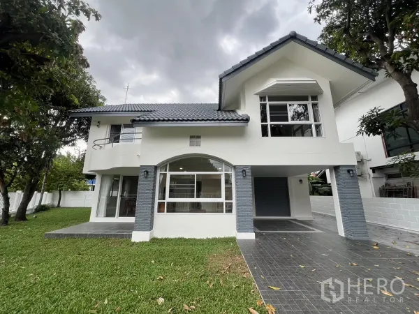 独立式住宅 出租在Saphan Sung, Bangkok - 白色两层独栋住宅，灰色屋顶，前院大草坪与成树。