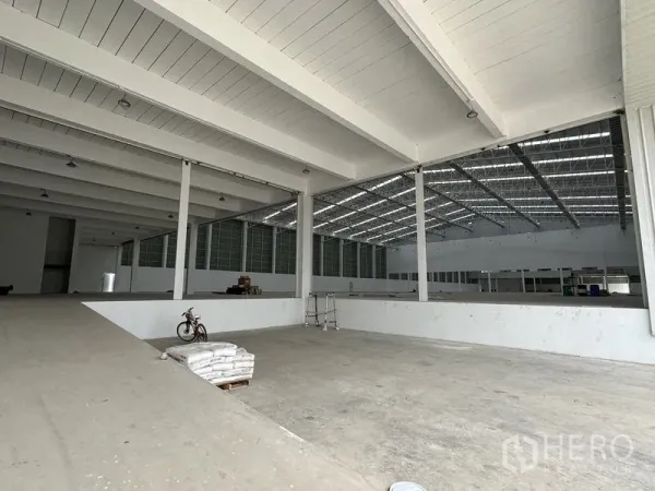 Factory for rent in Pathum Thani - Split-level production floor with skylights and wide-span beams inside the factory.