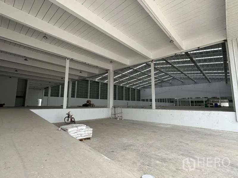 Factory for rent in Pathum Thani - Split-level production floor with skylights and wide-span beams inside the factory.