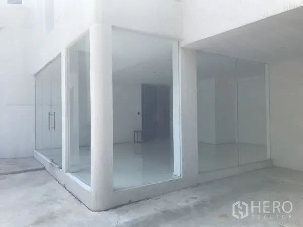 零售空间 出租在Khlong Toei, Bangkok - 一层转角零售铺面，双侧落地玻璃与白色外立面。