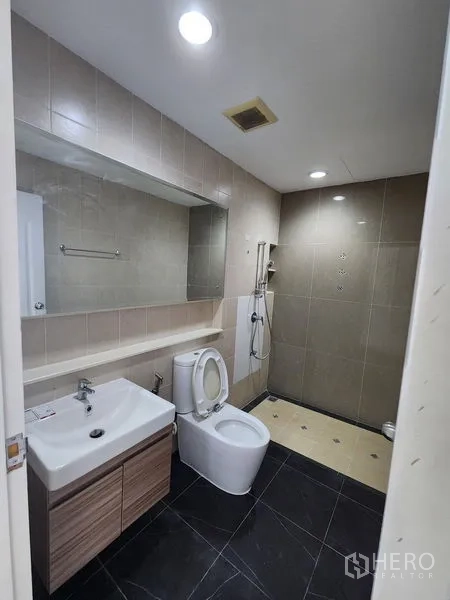 Townhouse for rent in Wang Thonglang, Bangkok - Modern bathroom with vanity, large mirror, toilet and walk-in shower.