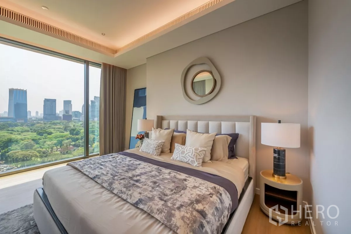 Condominium for rent or sale in Pathum Wan, Bangkok - Primary bedroom with king bed and panoramic park and city views through a large window.