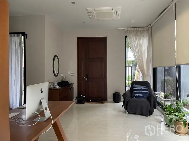 联排别墅 出售在Lat Phrao, Bangkok - 入口大厅，深色木门、亮面地砖与带百叶的窗户。