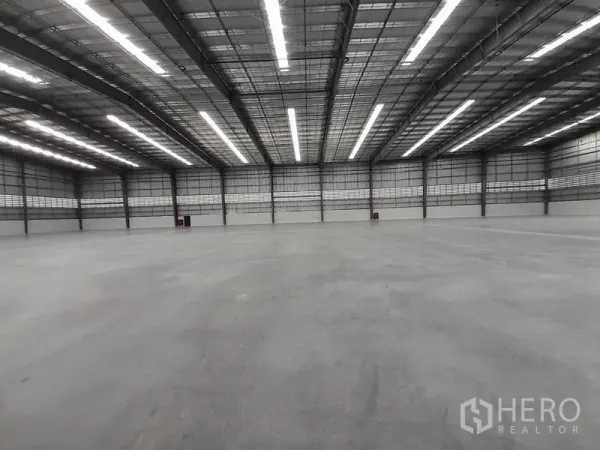 工厂 出租在Mueang Rayong, Rayong - 高挑空的仓储空间，整排LED灯与抛光混凝土地面。