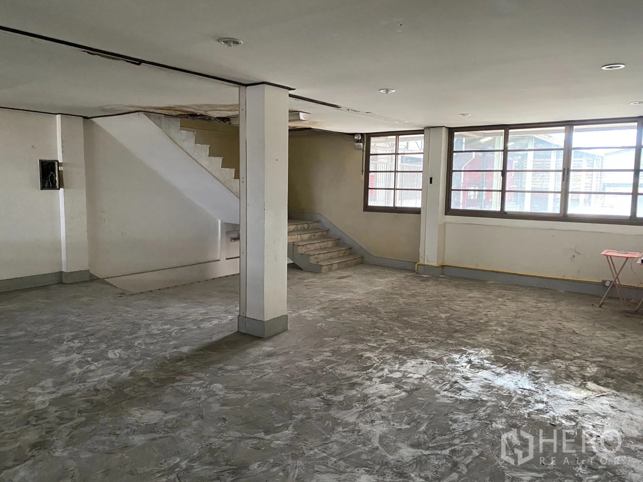 零售空间 出租在Yan Nawa, Bangkok - 宽敞的上层空间，带楼梯、大窗与水泥地面。