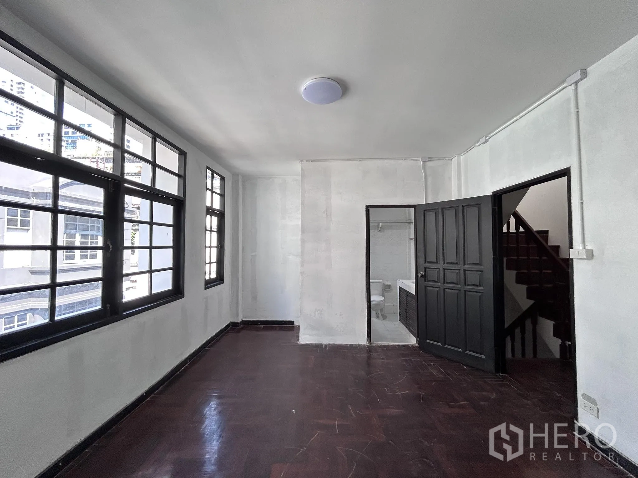 家庭办公室 for rent or sale in Watthana, Bangkok - 角落房间，木地板、大窗户，带卫生间入口。
