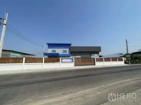 工厂 出租或出售在Bang Phli, Samut Prakan - Bang Phli新建工厂外观，蓝色两层办公室与围墙大门面向道路。