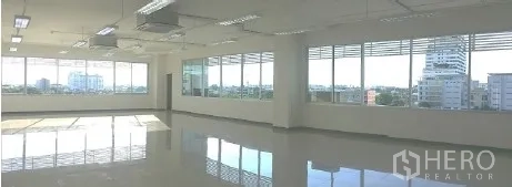 Office Space for rent in Bangkok - Bright open-plan office floor with large windows, glossy tiles, ceiling lights and city views.